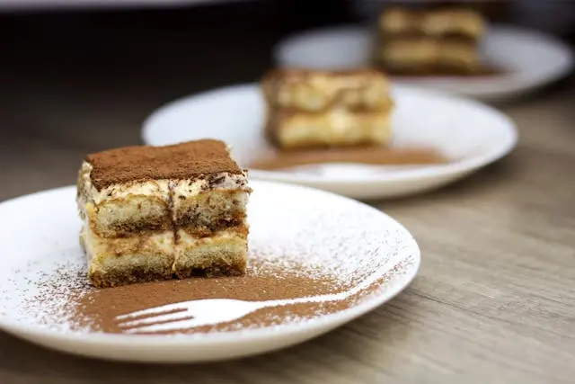 Klassisk italiensk tiramisu serverad som dessert efter en kulinarisk upplevelse i Rom.