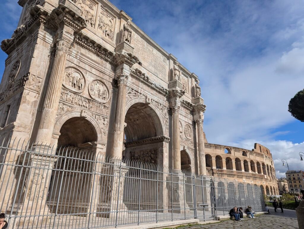 Arch of Constantine with its detailed relief carvings, Colosseum visible in the background