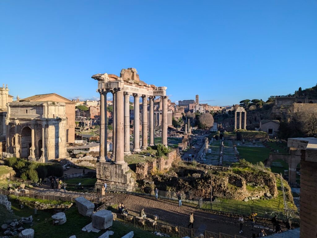 Panoramic view of the Roman Forum with the Temple of Saturn's columns and the Colosseum in the distance