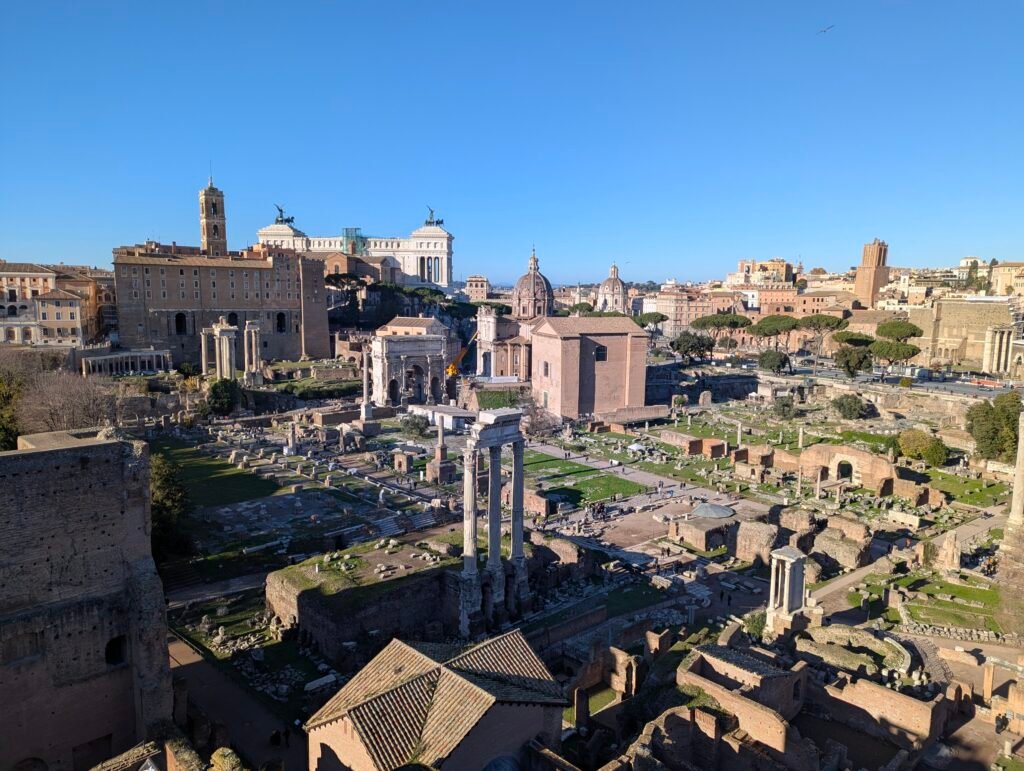 Aerial view of the Roman Forum ruins with the Vittoriano monument and Arch of Septimius Severus in the background