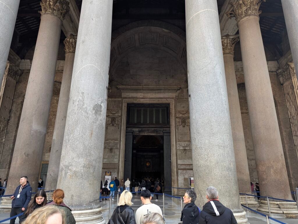 Imponerende utsikt som ser opp på de massive granittsøylene og den monumentale inngangen til det gamle Pantheon i Roma.