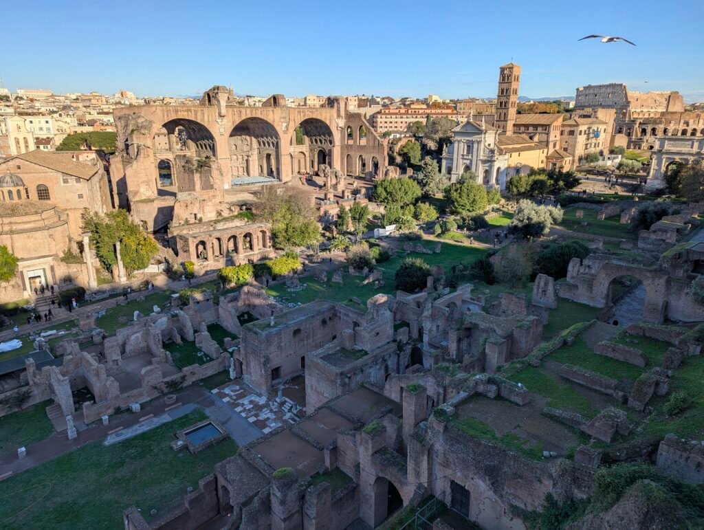 Vy över Forum Romanums ruiner med Maxentius-basilikan och Colosseum i bakgrunden