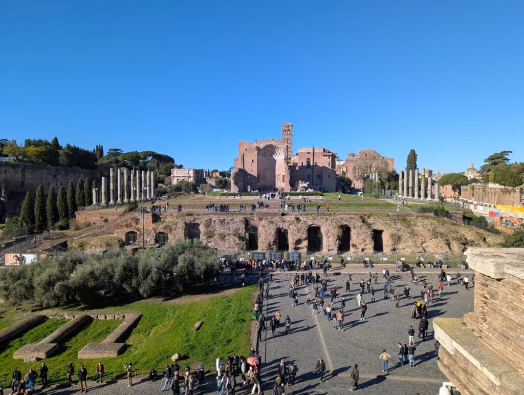 Utsikt över Venus och Roma-templet med dess pelarportik, sedd från Colosseum med besökare nedanför